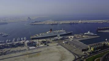 Huge cruise ship is on the water. Aerial view of Dubai seaport United Arab Emirates . Top view of the construction of a water port in Dubai photo