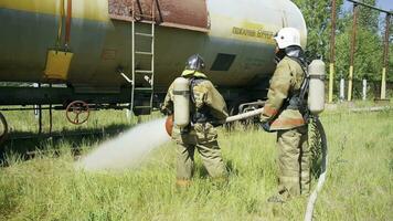 Firefighters near the equipment. Clip. Two men use a huge jet of water to check fire equipment. photo