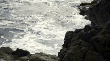 el olas luchando acerca de el rocoso Oceano costa. acción. ver de el furioso olas de el mar rotura en el rocas foto