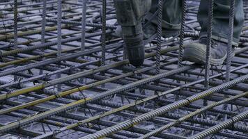 Construction worker. Worker in the construction site making reinforcement metal framework for concrete pouring photo