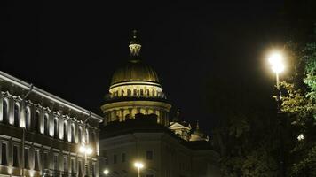 Historical building with lighting on background of Cathedral at night. Action. Beautiful old architecture glows at night. Dome of Cathedral is brightly lit in night photo