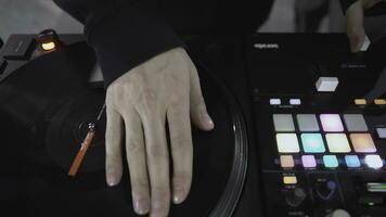 DJ spinning record at disco. Art. Close-up of DJ's hand on mixer. Glowing music panel at party. Musician's work in nightclub photo