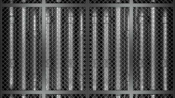 Abstract rows of metal pipes behind metal grid. Design. Abstract industrial background with silver tubes behind the fence. photo