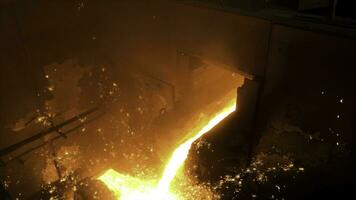 Close up for molten metal poured from ladle for casting at the foundry. Stock footage. Smelting of metal casting, metallurgical production at the hot shop of a factory. photo