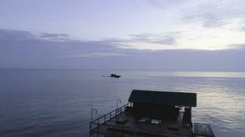 Beautiful wooden bungalow surrounded by breathtaking ocean water. Shot. Stunning ocean view with blue sky and small bungalow. photo