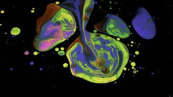 Fantastic surface with multicolored acrylic paints mixed on black background. Stock footage. Close up of bright acrylic inks drops looking like amazing contrast stains. photo
