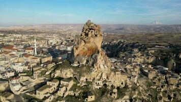 antenne dar visie van de ortahisar kasteel in Cappadocië, kalkoen met de sneeuw afgedekt monteren erciyes in de achtergrond. mensen genieten van de visie van de top van de kasteel. video