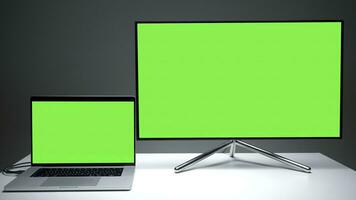New TV models. Action.A small laptop that is comfortable to use and a large plasma TV with green screens. photo