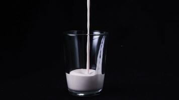 Close-up of clean glass filled by strawberry milkshake. Frame. Isolated on black photo