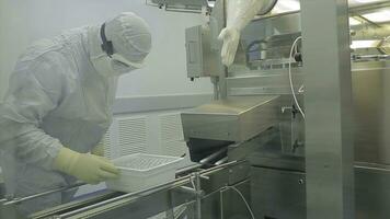 Pharmaceutical industry. Male factory worker inspecting quality of pills packaging in pharmaceutical factory. Automatic tape to create packaging and filling of medicines. control in the factory of photo