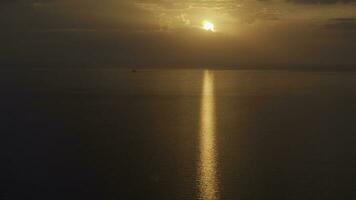 Aerial view of a golden sunset sky background with evening clouds over the sea. Shot. Stunning sky clouds in the sunset with a bright sun path on the sea surface. photo