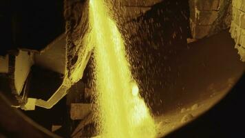 Molten raw materials in furnace. Stock footage. Close-up of bright molten substance pouring out in stream in industrial furnace photo