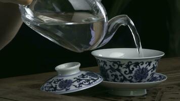 proceso fabricación de cerveza té, té ceremonia, copa de recién elaborada negro té. asiático té conjunto en bambú estera, primer plano. el chino desde un emitir tetera foto
