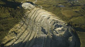 Panoramic view of quarry. Shot. Top view of picturesque quarry located on coastal mountain near village in forest. Concept of mining photo