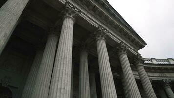 Colonnade with corinthian orders of ancient building. Action. Bottom view of beautiful white columns of old building. Colonnade of Kazan Cathedral in Saint Petersburg photo