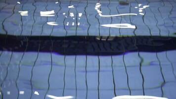 difuminar de ligero reflejando en azul agua de el piscina. claro agua balanceo, nadando piscina agua textura. foto