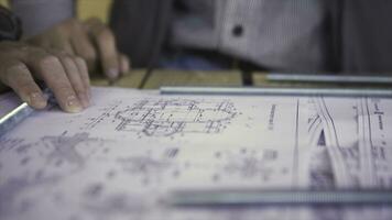 Close up view on engineer hand pointing at technical drawings. Men hands indicating some details in papers, blueprints with building project. photo