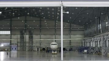 Roller shutter door and concrete floor of airport hangar and airplane background. Airport hangar from the outside with big tall doors. Front view. Aircraft Hangar photo