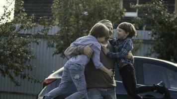 Father meets his little boys near his car outdoors. Stock. Concept of happy family and fatherhood. photo