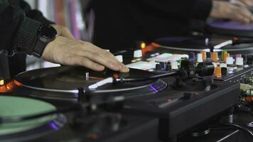 DJs play records at the disco. Art. Close-up of DJ's hand on the mixer. Glowing music panel at a party. The work of musicians in a nightclub photo