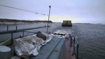 View from the ship on a barge trailer with goods. Clip. Concept of water transportation, containers on a barge and a wide river. photo