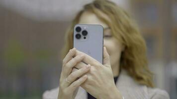Rusia, Moscú - septiembre 27, 2021. mujer toma fotos en nuevo iphone acción. mujer pruebas cámara de nuevo iphone 13 nuevo iphone con Tres cámaras y profesional disparo calidad