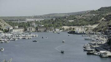 Aerial view of luxury port on a summer day with many yachts. Action. Summer small town with growing trees and mountains. photo