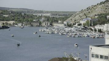 Aerial view of luxury port on a summer day with many yachts. Action. Summer small town with growing trees and mountains. photo