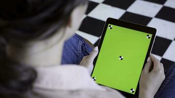 Close-up of man holding tablet and touching green screen. Stock fooatge. Young freelancer uses tablet to work or create projects. Tablet with green screen to insert photo