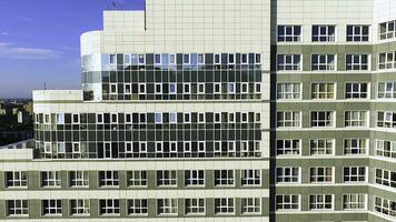 Aerial view on apartment building or apartment building with sun reflection. Clip. Big white modern apartment building view from the sky, photo