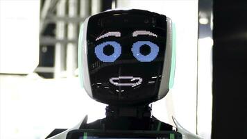 gracioso robot con grande azul ojos sonriente y hablando. meida. cerca arriba de robot cara pantalla con simpático sonrisa a el exposición de moderno tecnologías. foto