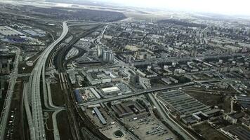 Top view of gray metropolis. Panorama of big city with areas and passing long highway in cloudy weather. Suburban industrial part of city on background of residential districts photo