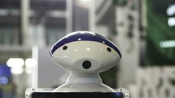 Close up of the moving humanoid robot with a camera on his head. Media. New technological robot moving at the exhibitional center, technologies of the future. photo