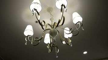 Luxury Chandelier. Close-up shot of modern lighting lamp with light bulbs on on a ceiling photo