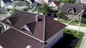 Top view of roof of country house. Stock footage. Beautiful new roof of house located in village. Roof maroon or dark red looks expensive and beautiful photo