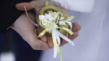 Wedding symbol, lock in hands of bride and groom. Newlyweds fix the lock on the bridge as a symbol of love. Padlock in the hands of the bride and groom. Lock in heart shape on the railing of bridge - photo