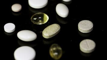 Various colorful pills on black background. Pile of several medicines on black background. Colorful pills over dark background. white pills on black glass background. medical pharmacy photo