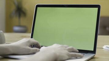 un hombre es trabajando a hogar y utilizando ordenador portátil con verde pantalla, comunicación y negocio concepto. valores imágenes. hombre mecanografía en su computadora con croma llave. foto