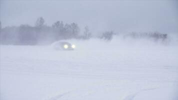 Snowy road in forest with car by and making a 180 turn slow motion . Car is making a drift in the snow. Car rides on a snowy road in winter time photo