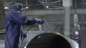 Male holding spray gun and painted steel. Man paints pipe atomizer photo