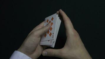 Poker game - shuffling cards. Man's hands shuffing cards. Close up. Man's hands shuffling playing cards. Dealer's hands shuffling cards during a poker game photo