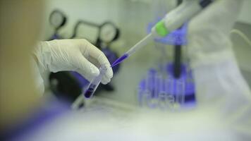 Test tubes closeup. Medical equipment. Close-up footage of a scientist using a micro pipette in a laboratory. Laboratory technician injecting liquid into a microtiter plate. Test tubes. Small depth of photo