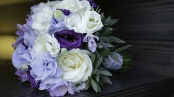 Perfect bouquet of creme luxurious roses for wedding, birthday or Valentine's day. Black old wooden background, top view. the bride's bouquet on black wood. Blue and white and pink roses photo