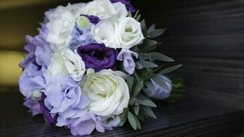 Perfect bouquet of creme luxurious roses for wedding, birthday or Valentine's day. Black old wooden background, top view. the bride's bouquet on black wood. Blue and white and pink roses photo