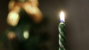 Close-up of festive candle on background of blurred lights. Concept. Clear focus on candle holder burning on background of festive colorful blurred lights photo