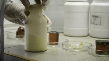 Researcher prepares to conduct chemical experiment in laboratory. Closeup of laboratory worker in gloves opens bottle with chemical substance, preparing for chemical experiment photo