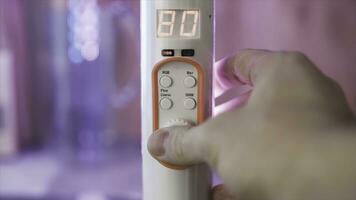 Close up of a hand turning remote controller of LED illumination in the room. Stock footage. Color of light in the room is being changed from pink to purple with a remote controller. photo