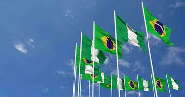 Nigeria und Brasilien Flaggen winken zusammen im das Himmel, nahtlos Schleife im Wind, Raum auf links Seite zum Design oder Information, 3d Rendern video