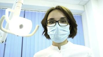 paciente punto de ver de un dentista examinando paciente boca, moderno odontología concepto. medios de comunicación. joven hembra dentista mirando a el paciente y torneado el lámpara. foto