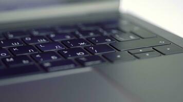 Close up of elegant modern laptop details. Action. Concept of modern technologies, Black keaboard and touch pad of a computer lying on white blurred background. photo